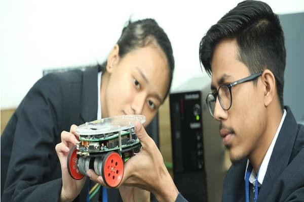 Students examining a robotic device